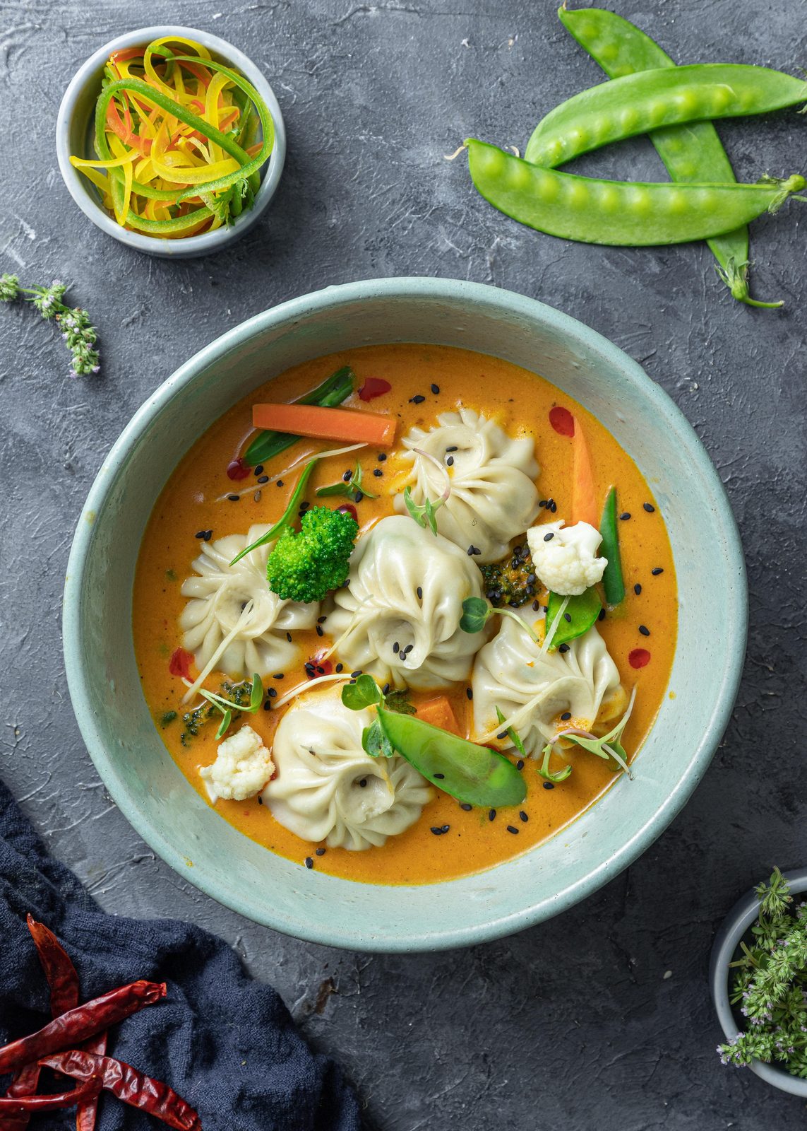 A bowl of steamed momos in a creamy curry, ready to be dipped